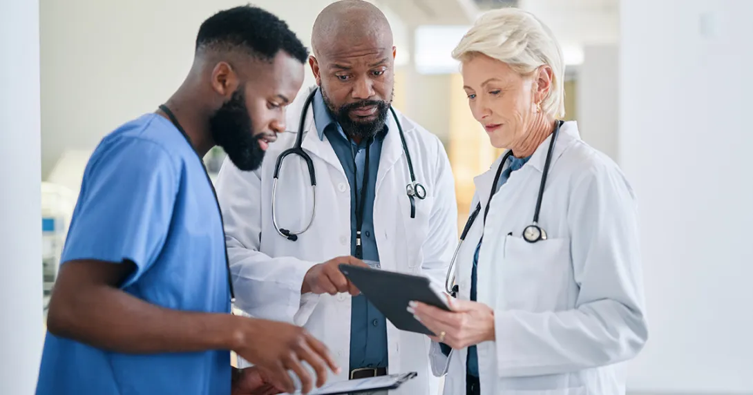 Group of healthcare workers looking at a tablet Group of healthcare workers looking at a tablet