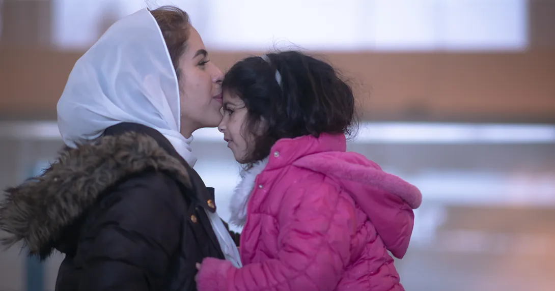 Adult kisses child on forehead