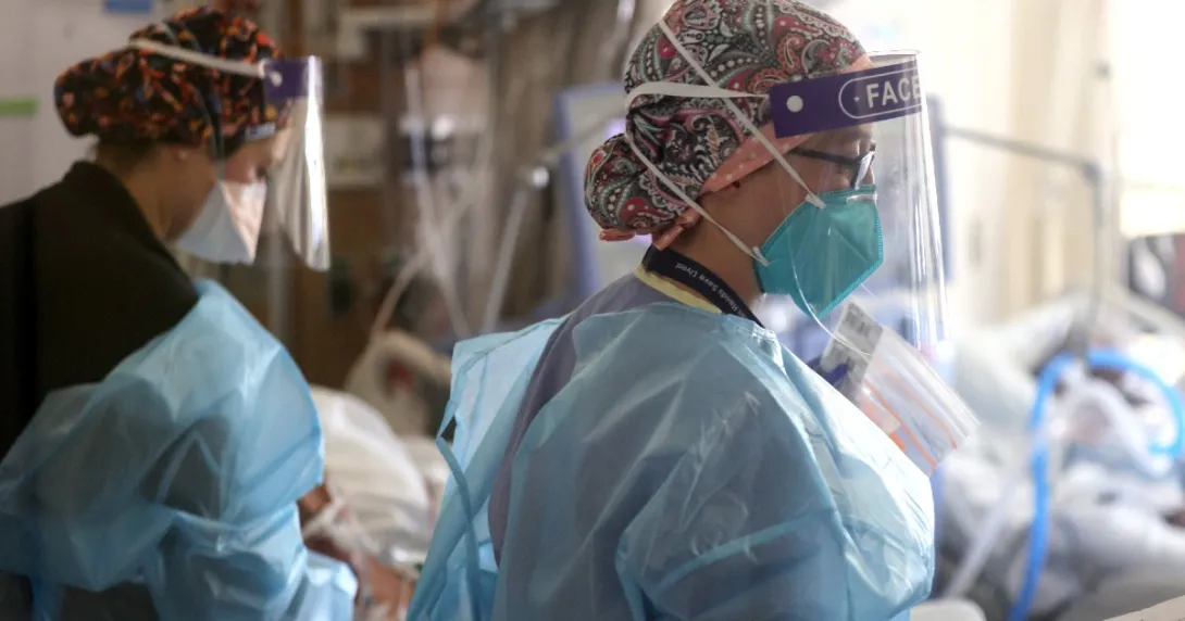 Clinicians wearing personal protective equipment treat patients at a hospital