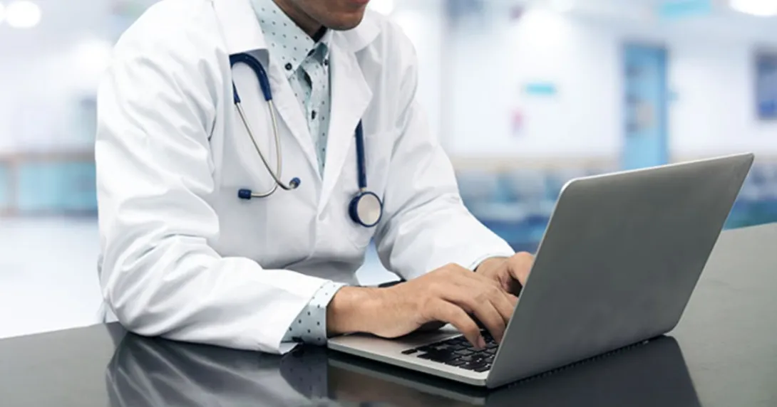 A person wearing a stethoscope on a computer