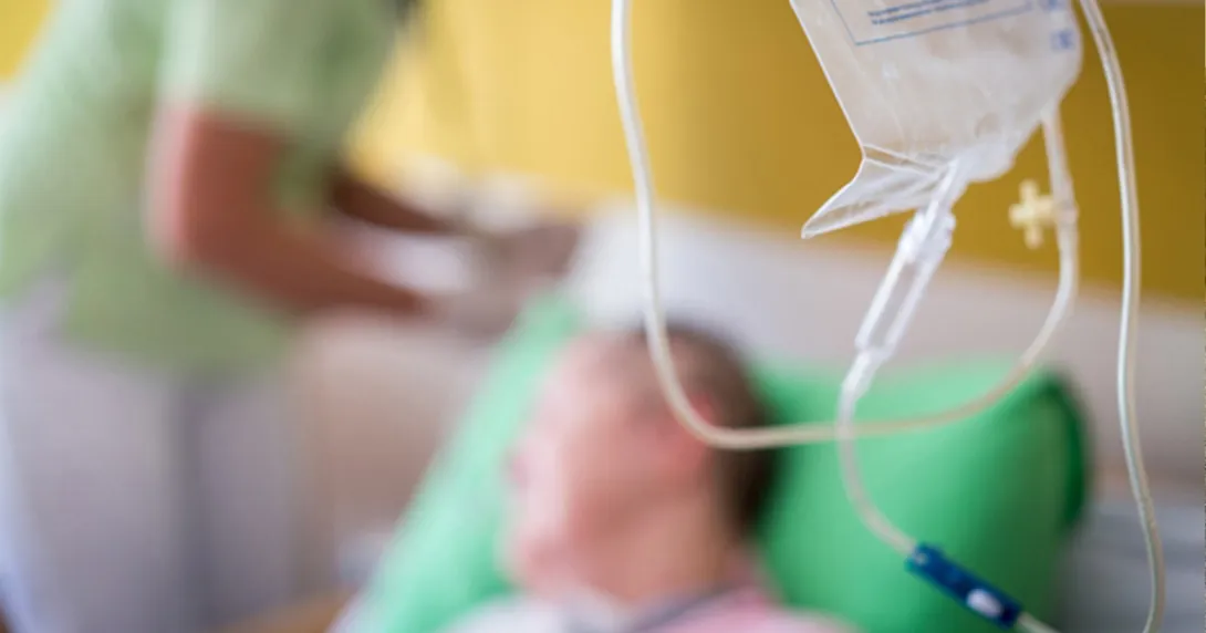 Infusion session Infusion bag in foreground with patient and infusion nurse in background