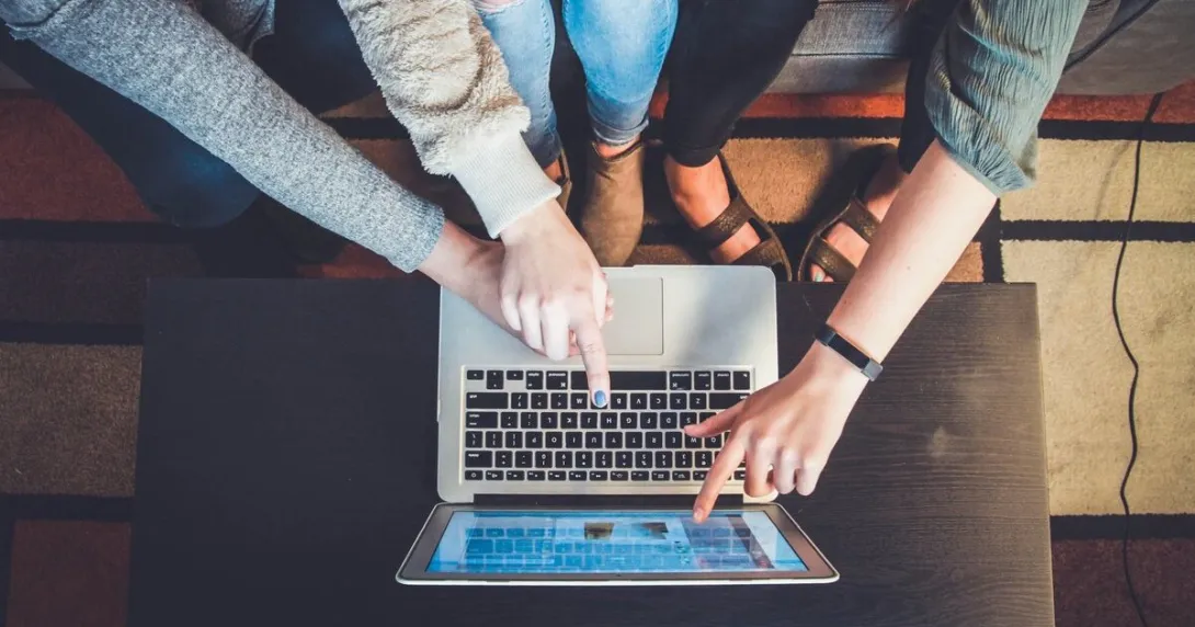 Teenagers pointing at a laptop screen
