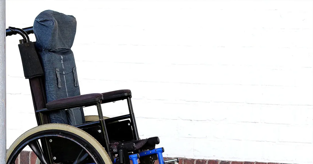 A wheelchair, perhaps for an ALS patient, sits vacant by a wall. A wheelchair, perhaps for an ALS patient, sits vacant by a wall.